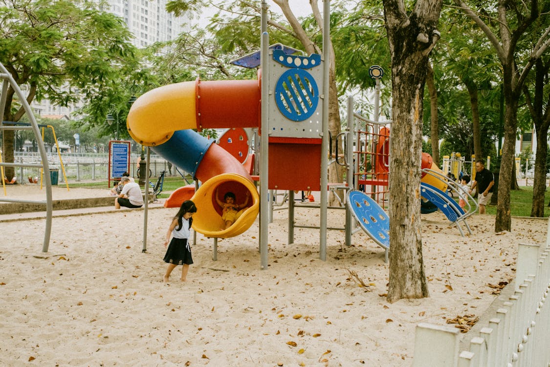 Kids enjoying colorful playground slides and play structures at a park similar to Kaleidoscope Park in Frisco Texas