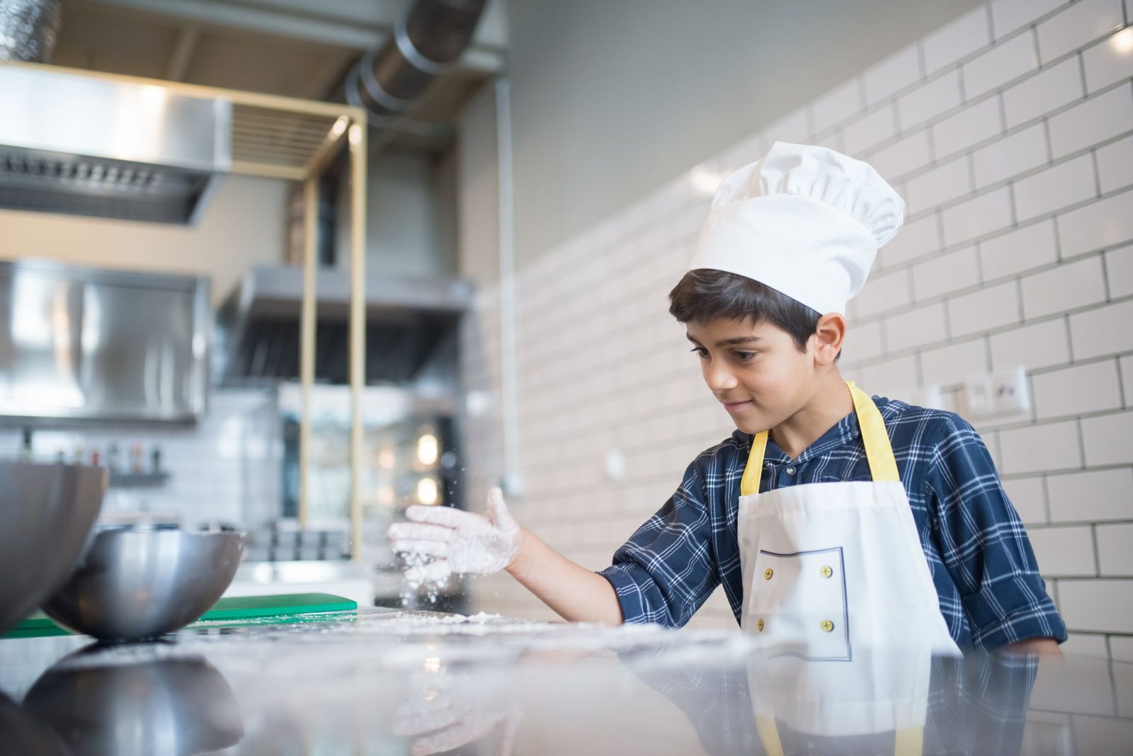 Kids cooking in the chef role-play activity at KidZania Frisco