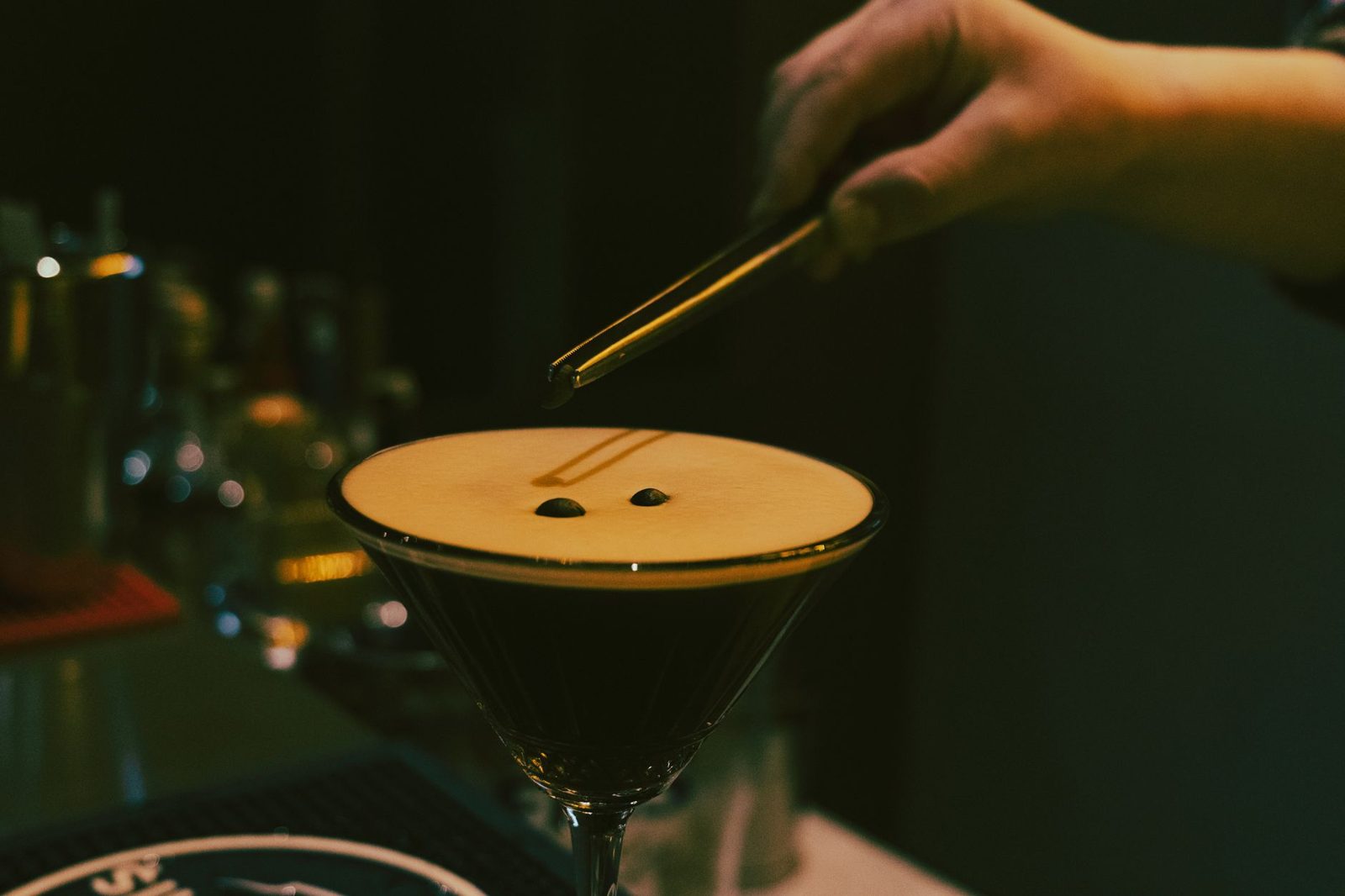 Bartender serving a craft cocktail in a dim lounge, the vibe at the best cocktail bars Frisco TX offers