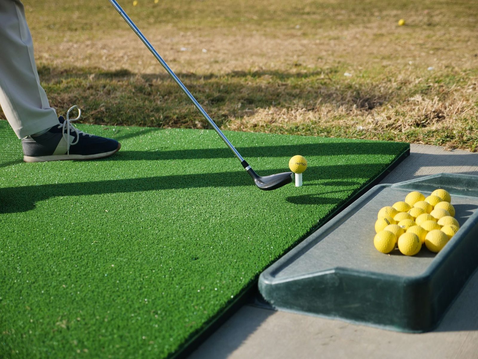 Golfer chipping onto a green with a wedge, short game practice