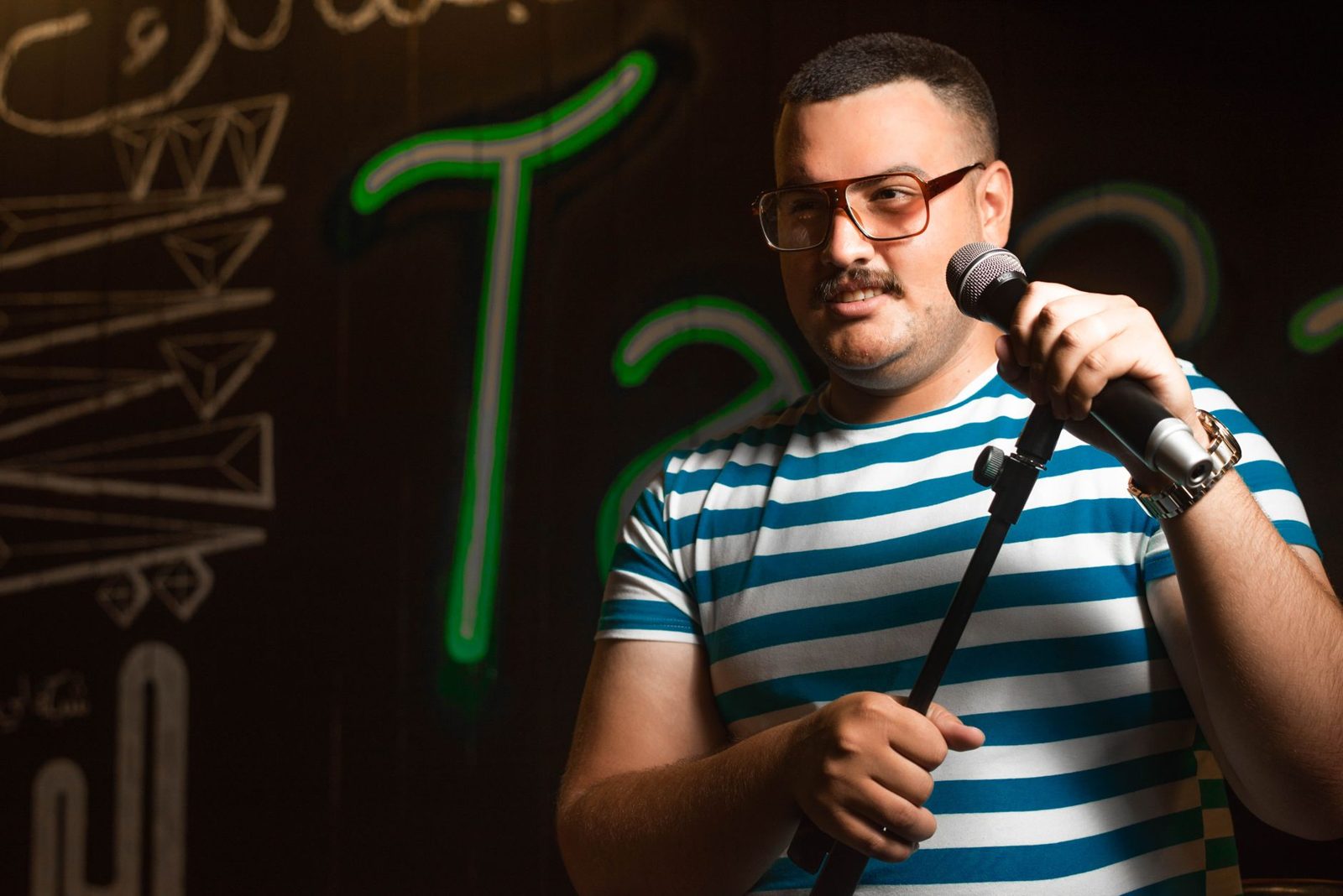 Comedian performing under spotlight at an open mic night in Frisco TX