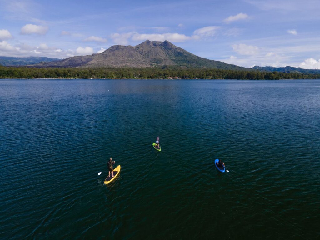 Aerial view of paddleboarders and kayakers on calm lake water