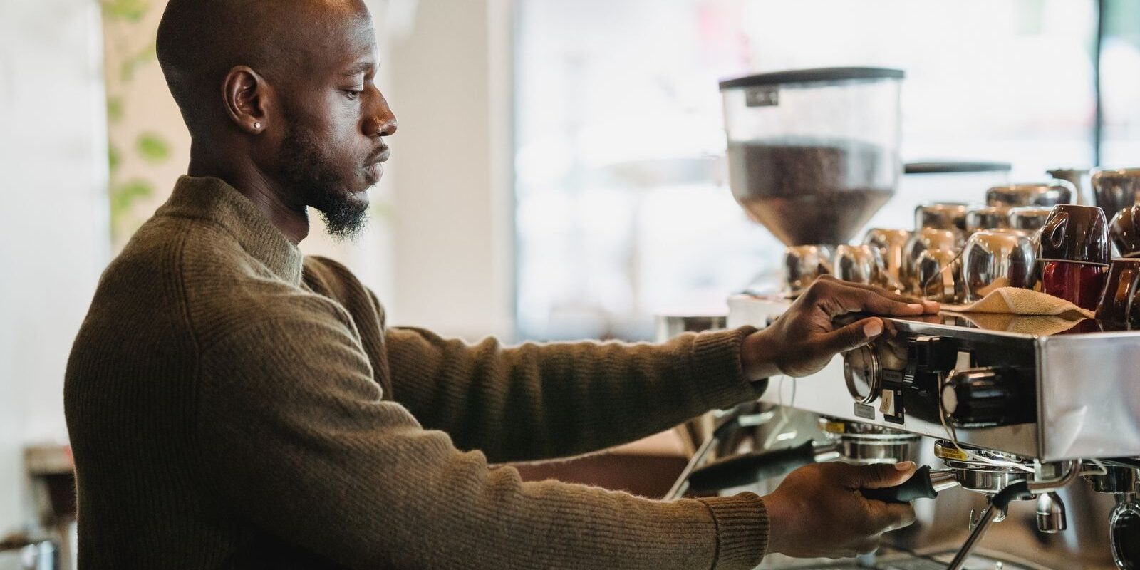 Barista pulling espresso behind a café counter, like the bars at coffee shops in Frisco TX
