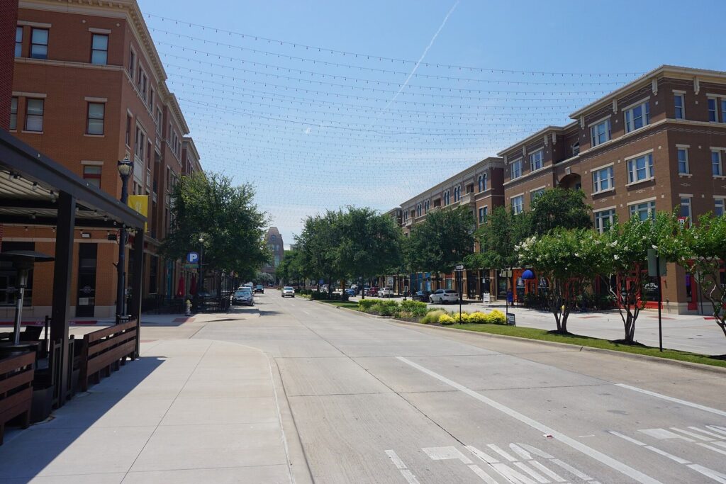 Brick mixed-use buildings and shaded patios along Coleman Boulevard in Frisco Square