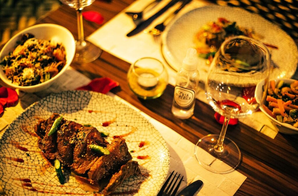 Candlelit steak dinner with a glass of red wine, the kind of meal couples book for an anniversary in Frisco TX