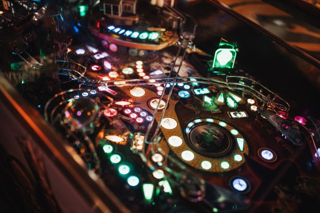 Close-up of an illuminated pinball playfield with glowing lights and bumpers