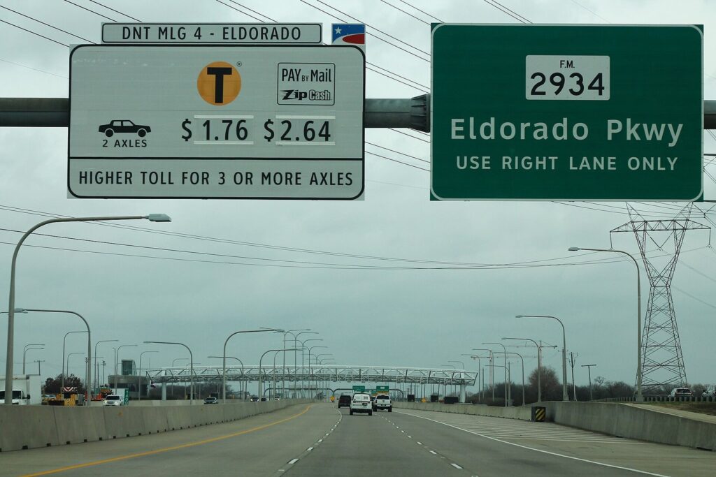 Dallas North Tollway toll sign and Eldorado Parkway exit sign above the northbound lanes in Frisco