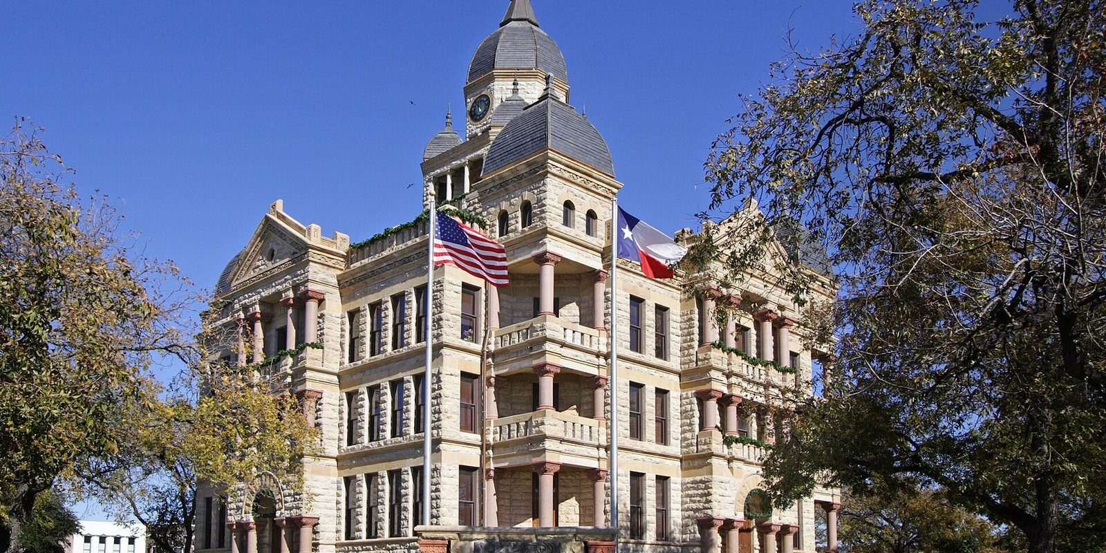 Denton County Courthouse-on-the-Square with its clock tower, flags and lawn, first stop on a Denton TX day trip