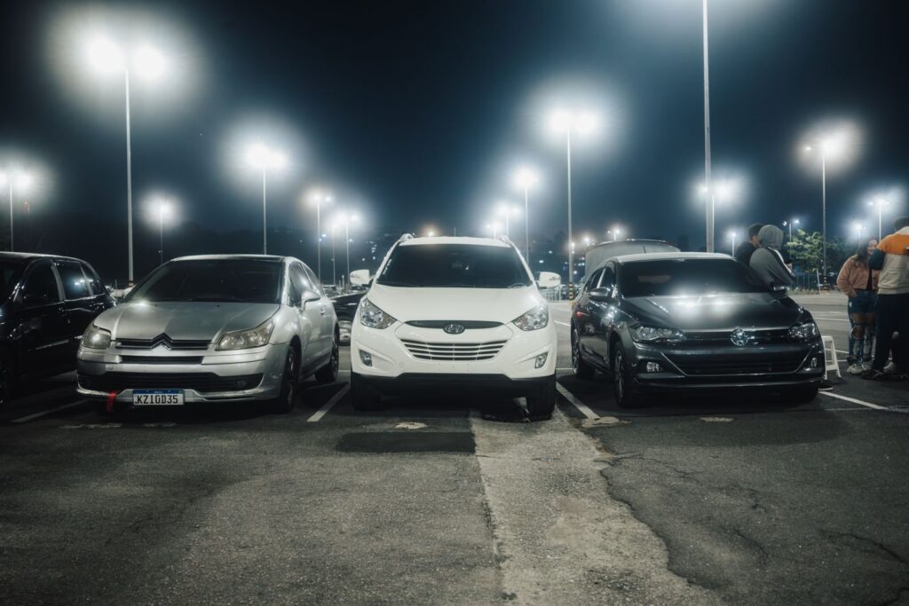 Frisco TX travel tips for parking: cars in a brightly lit parking lot at night