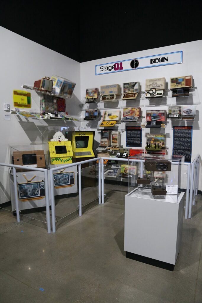 Glass shelves of vintage Pong home consoles on display at the National Videogame Museum