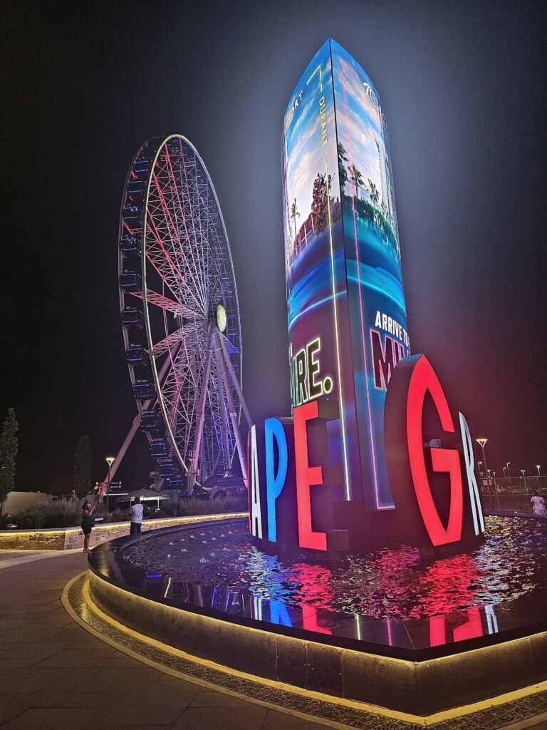 Grandscape's lit Ferris wheel and giant letter sign at night in The Colony, Texas