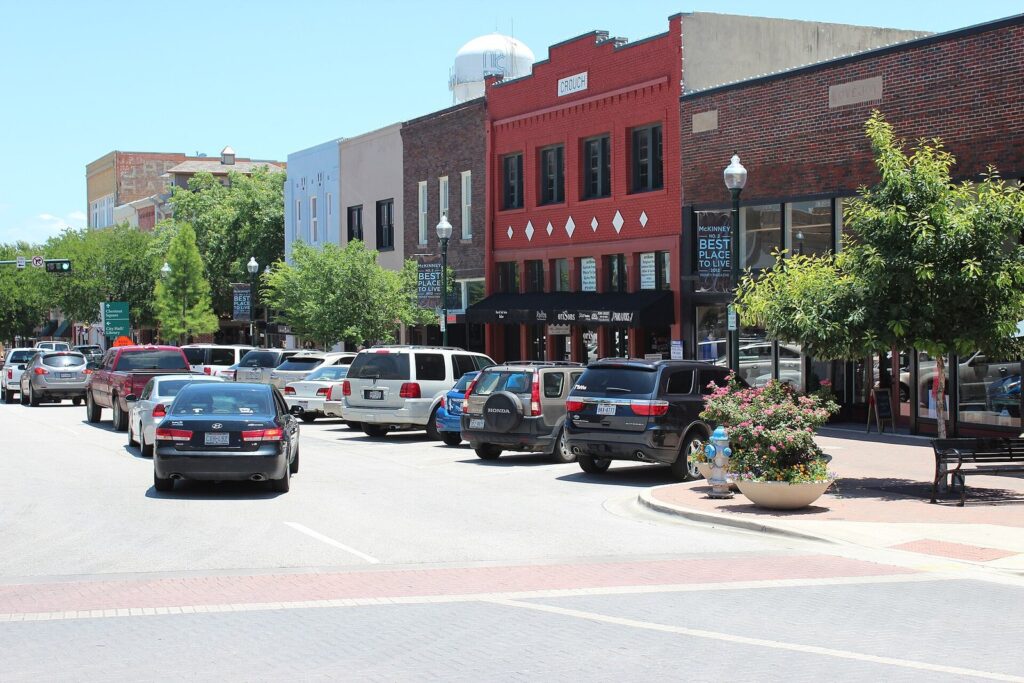 Historic brick storefronts and parked cars on the square in downtown McKinney
