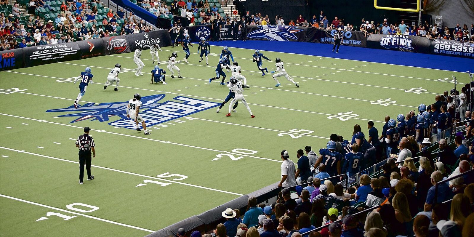 Indoor football players line up on the turf at Comerica Center in Frisco as fans fill the lower bowl