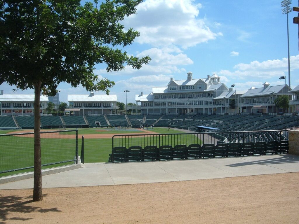 Left field grass, trees and the seating bowl at the Frisco RoughRiders ballpark