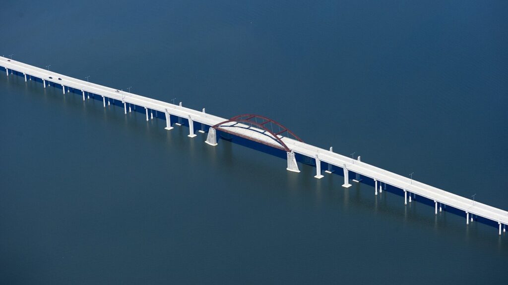 Lewisville Lake Toll Bridge with a red arch crossing deep blue water