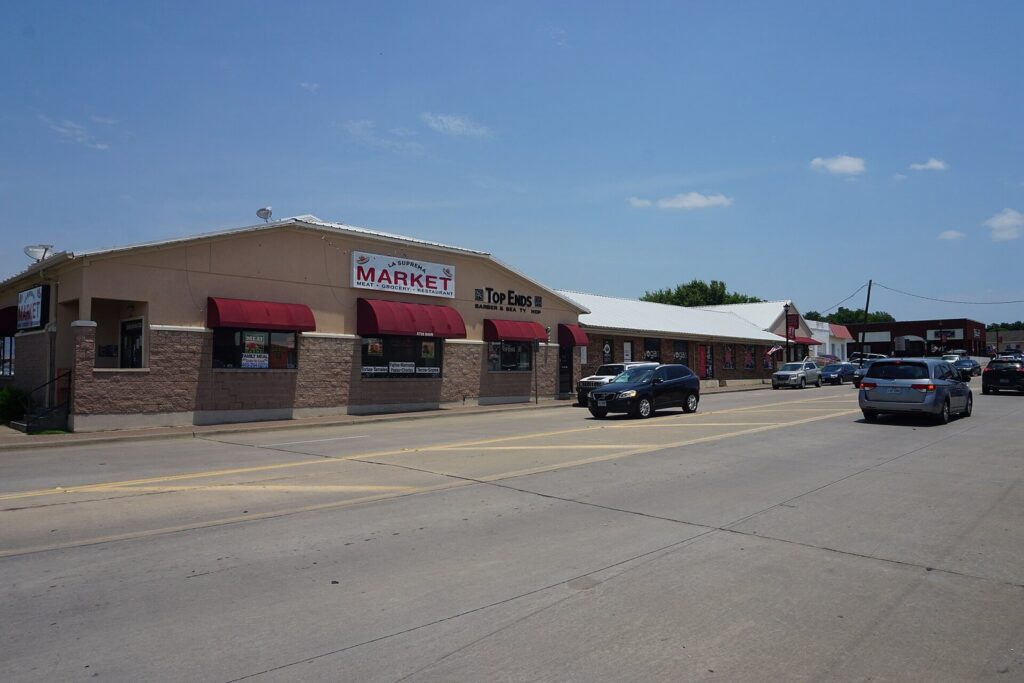 Low brick storefronts and parked cars along Main Street in Frisco's Rail District