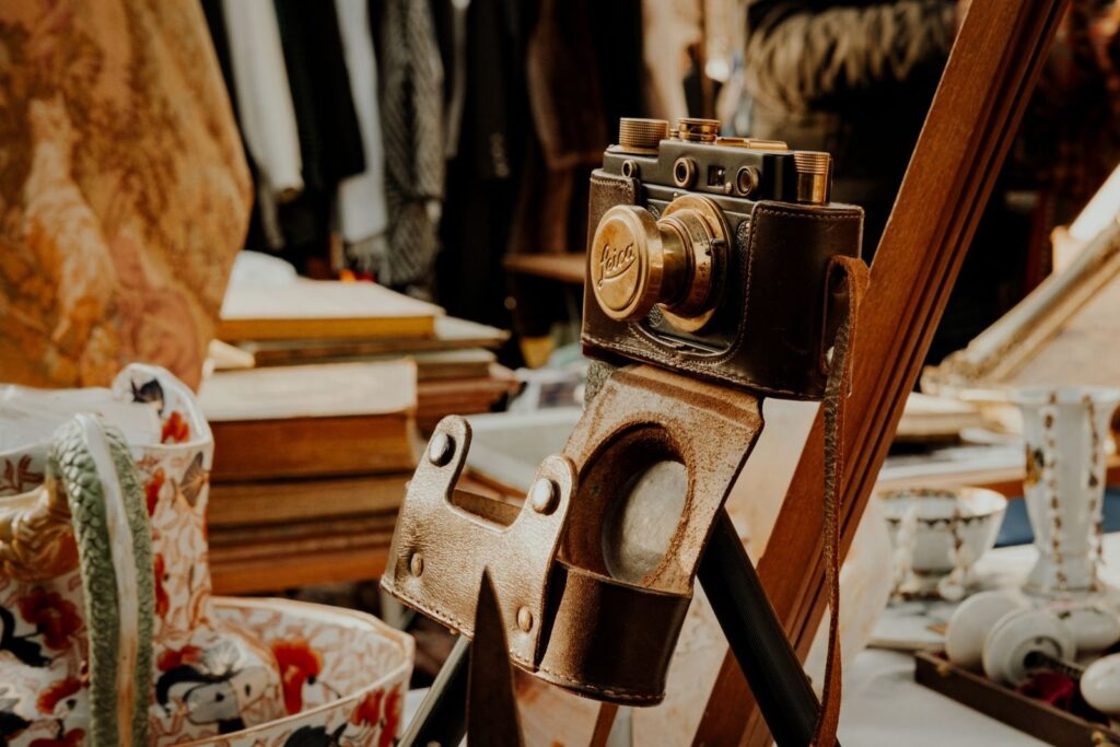 Old folding camera in a leather case on a table in an antique shop