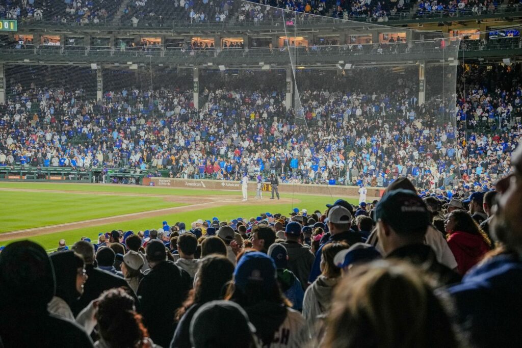 Packed stands at a minor league baseball game under the lights at night