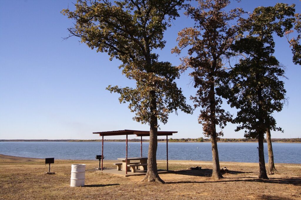 Picnic shelter and trees on the sandy shore of Lewisville Lake