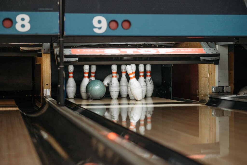 Planning bowling in Frisco TX: a ball rolling into a full rack of pins