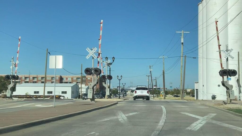 Railroad crossing on Main Street in Frisco with white grain silos beside the tracks