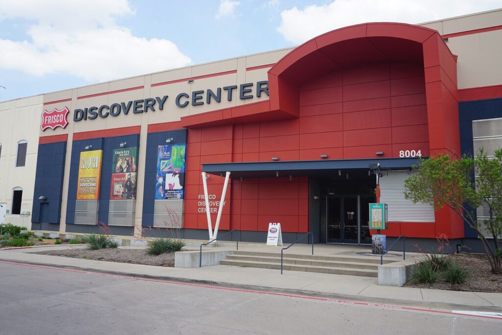 Red and blue entrance of the Frisco Discovery Center on Dallas Parkway