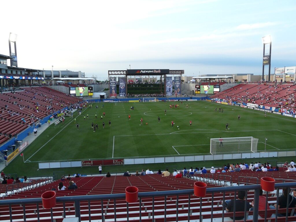 Red stadium seats and the pitch at Toyota Stadium during an FC Dallas match