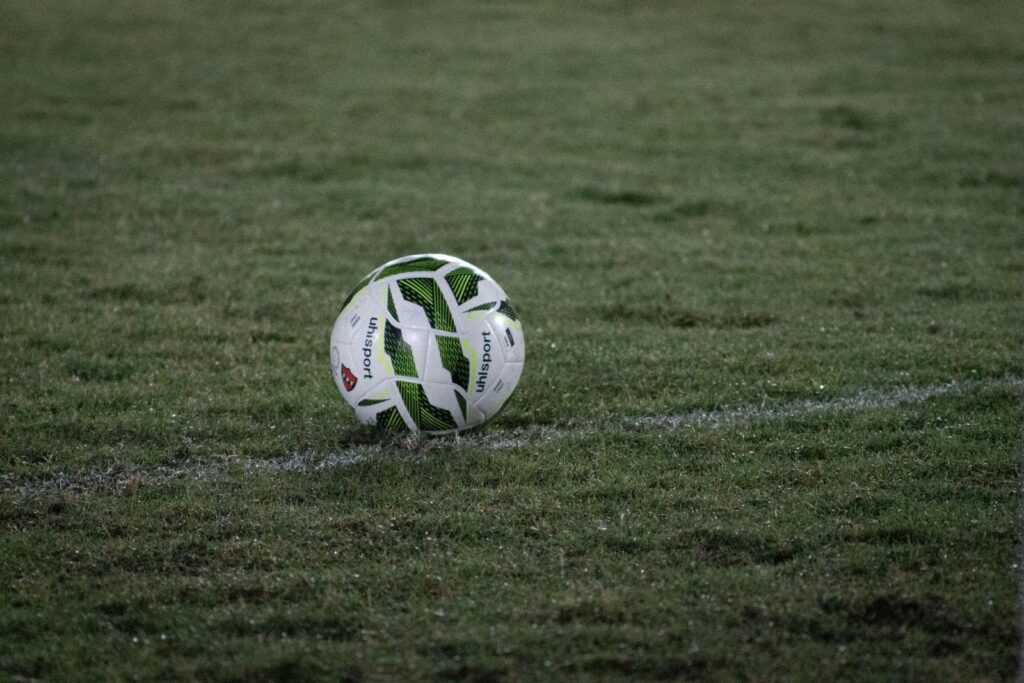 Soccer ball resting on a grass field at dusk