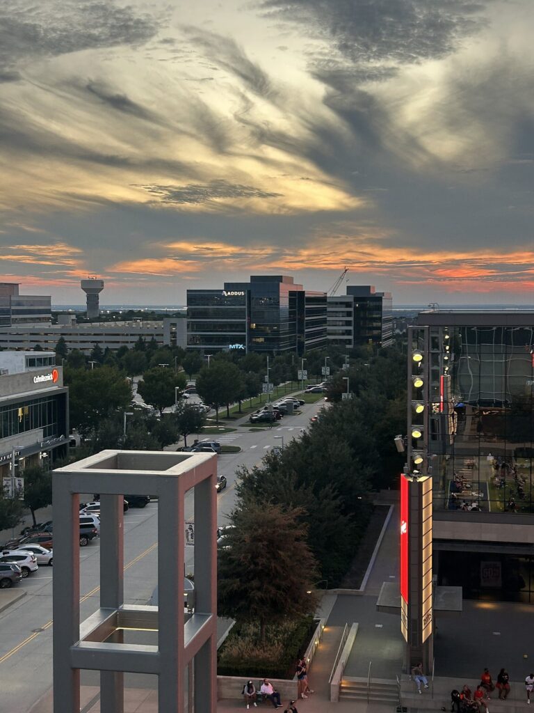 The Star district in Frisco at sunset, with office towers and a water tower beyond
