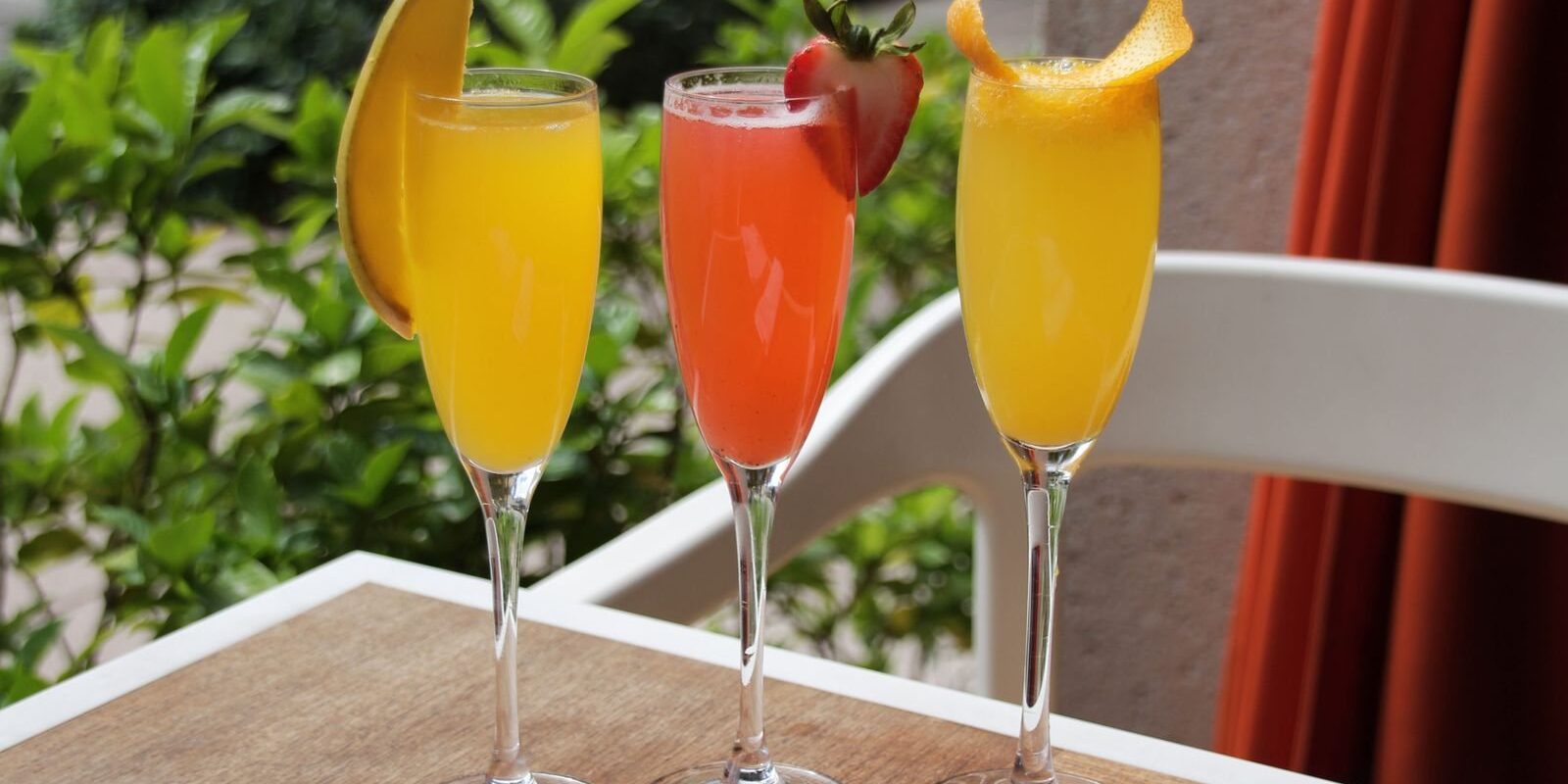 Three fruit mimosas on a sunny patio table, a classic start to brunch in Frisco TX