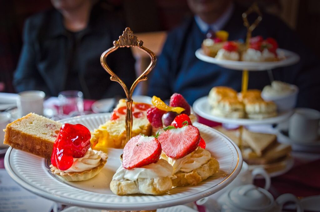 Tiered stand of scones, strawberry tarts and cakes set out for afternoon tea