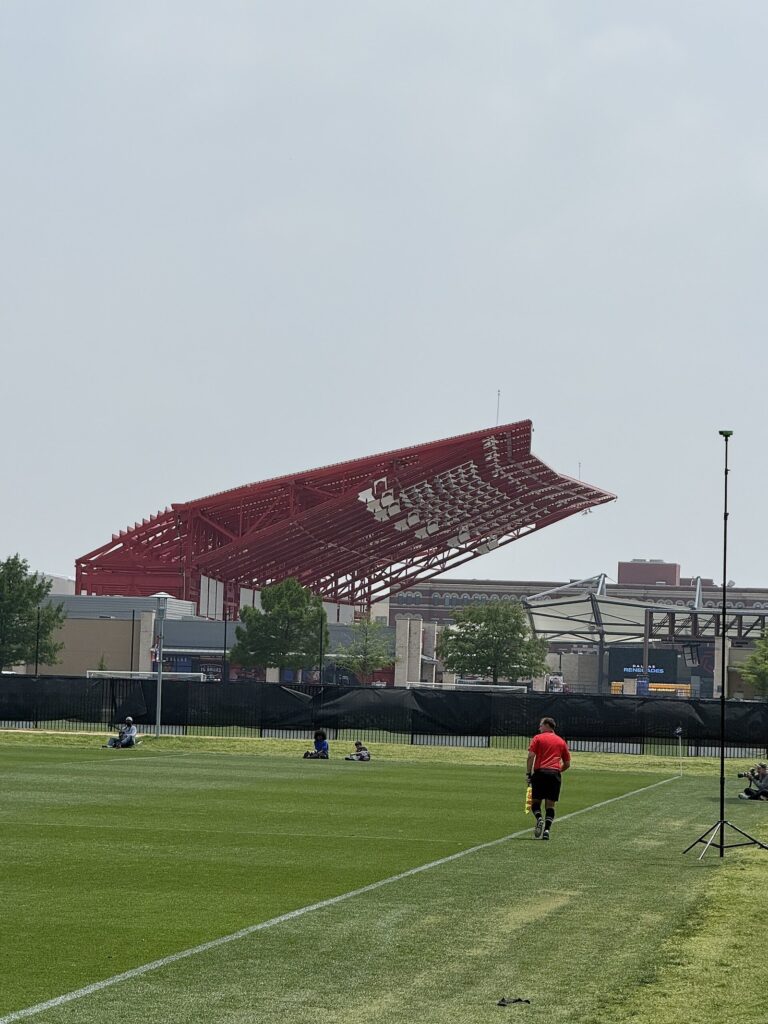 Toyota Stadium east stand roof seen across a soccer pitch under a gray sky