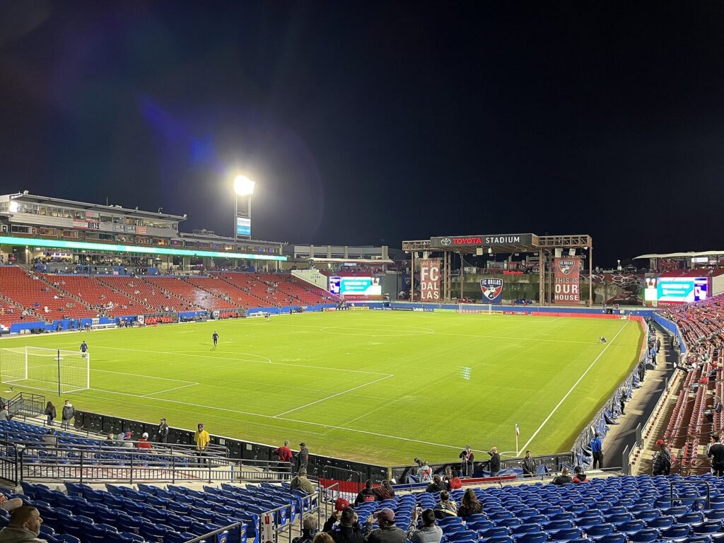 Toyota Stadium in Frisco lit at night with the pitch and stands in view