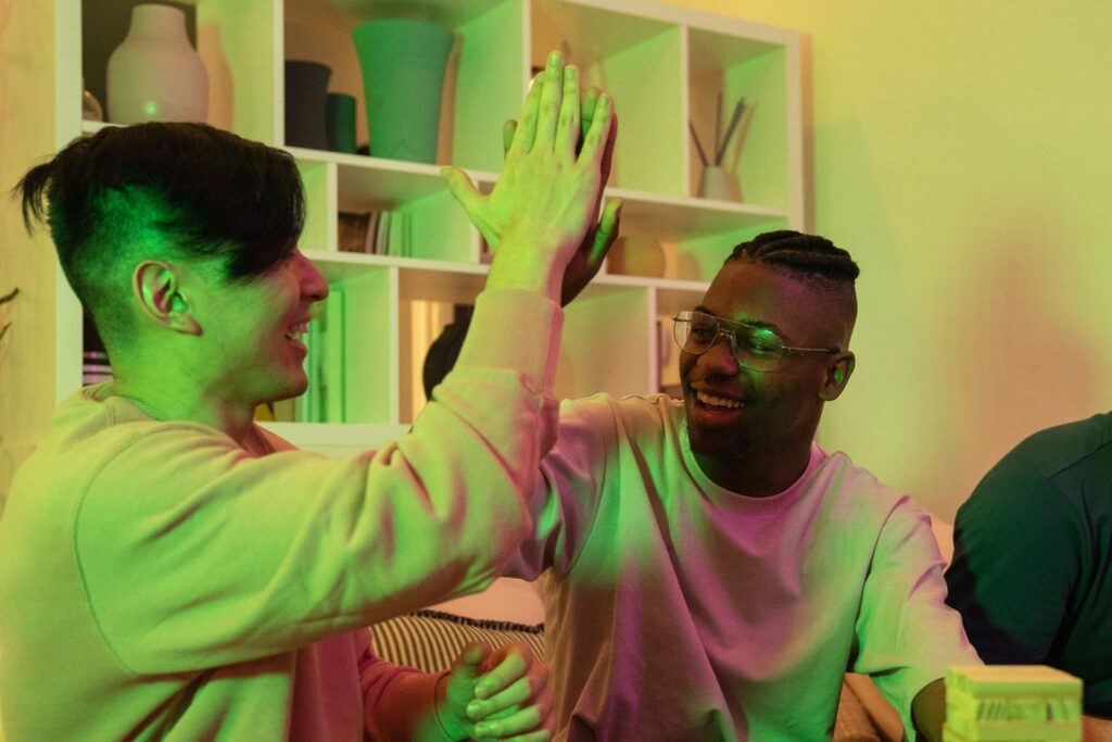 Two friends sharing a high five in a softly lit room