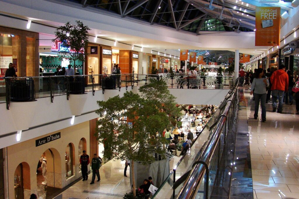 Two-level mall concourse with shoppers, skylights and planters at Stonebriar Centre