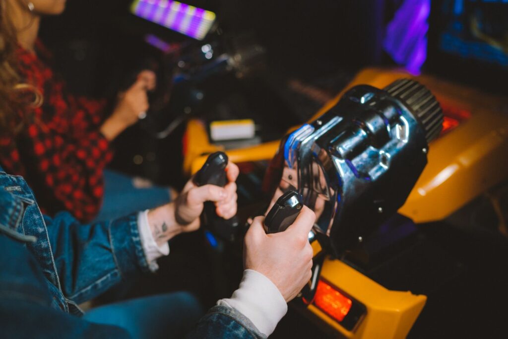 Two players gripping the wheels of a virtual reality driving game