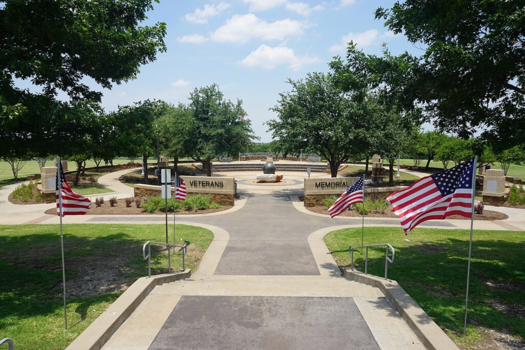 Walkway into the Frisco Veterans Memorial plaza lined with American flags